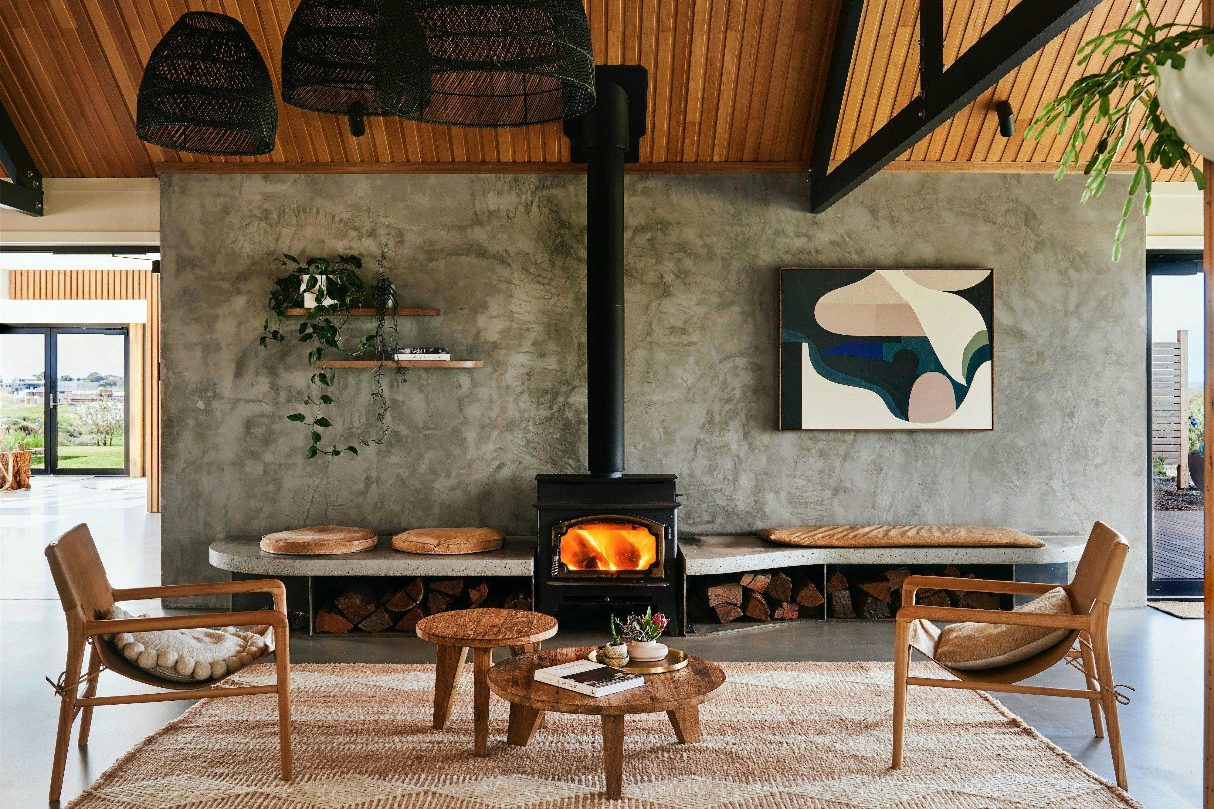 Lounge with timber ceiling, fireplace and armchairs at Lon Retreat in Point Lonsdale.