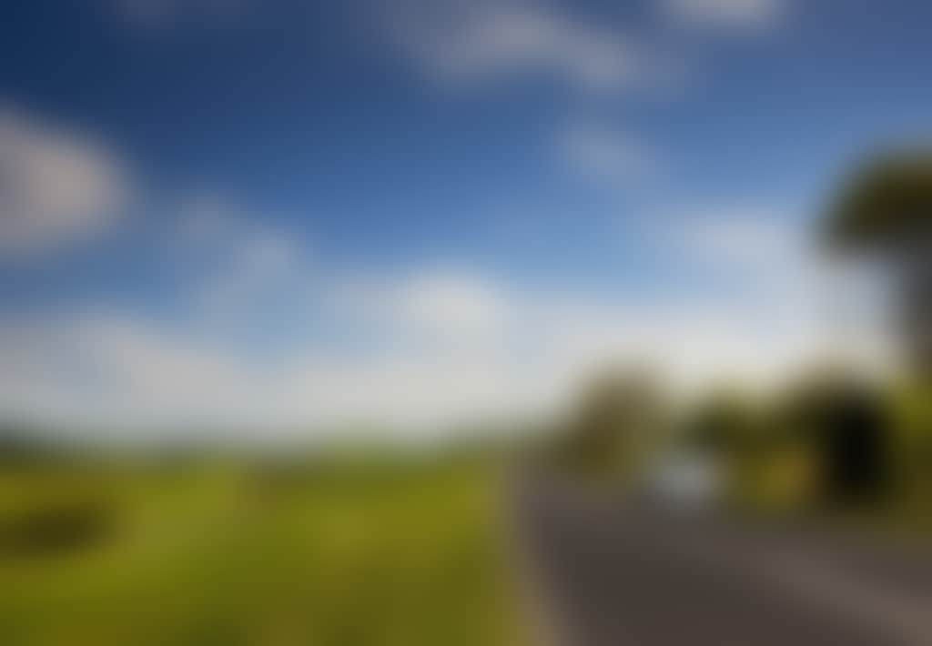 Car driving among the green rolling hills