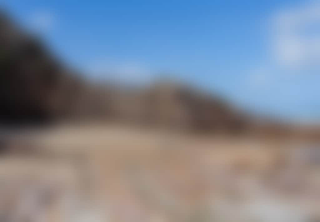 Quarry Beach Mallacoota woman walks on beach surrounded by rock formations