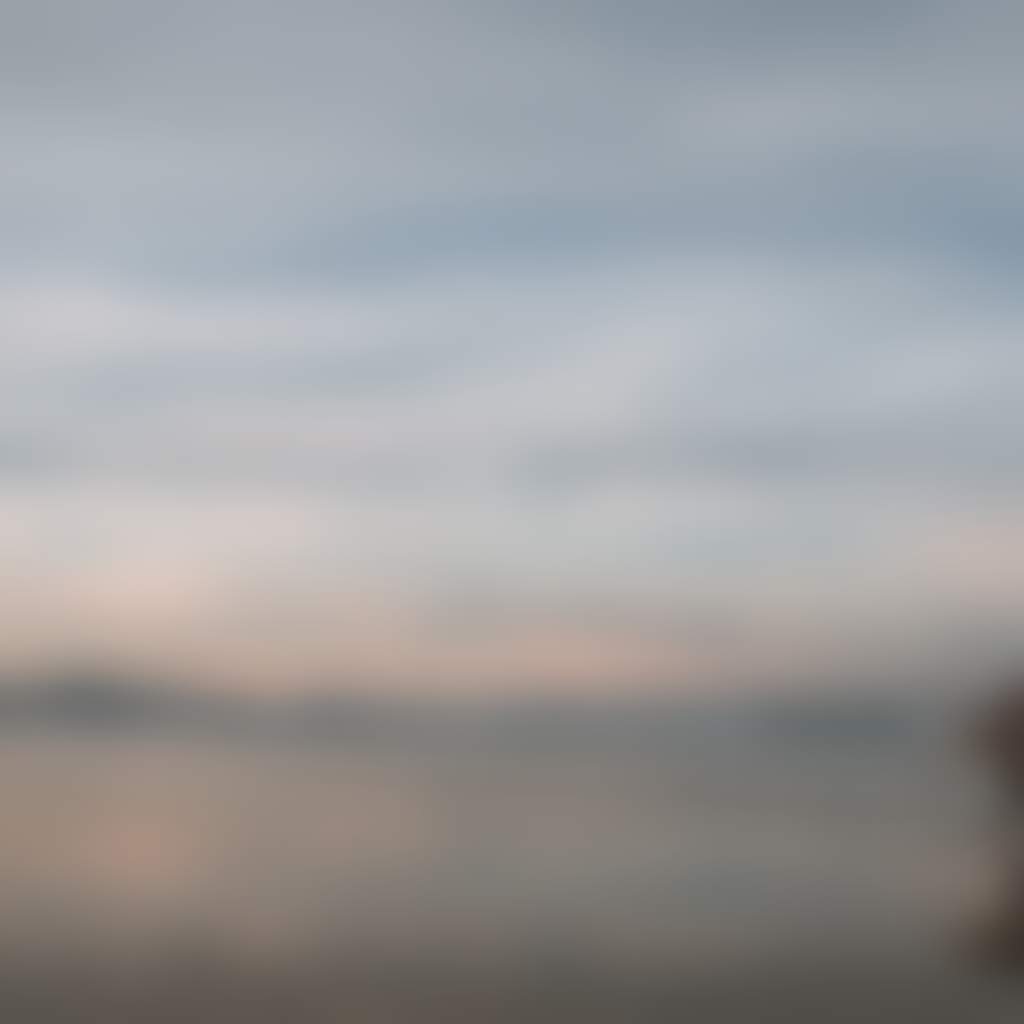 Sandy Point surfer walking across the beach at sunrise