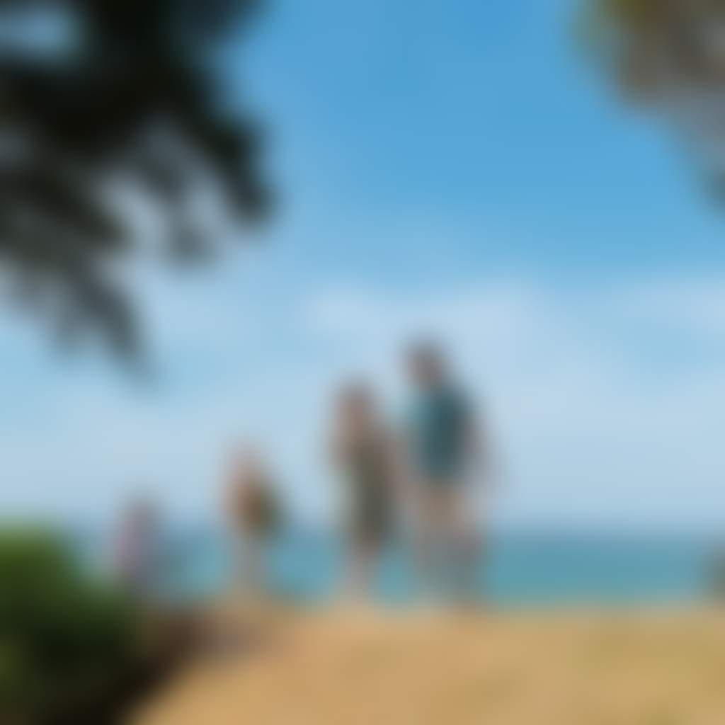 Corinella Beach family walking along hill with ocean and trees in background