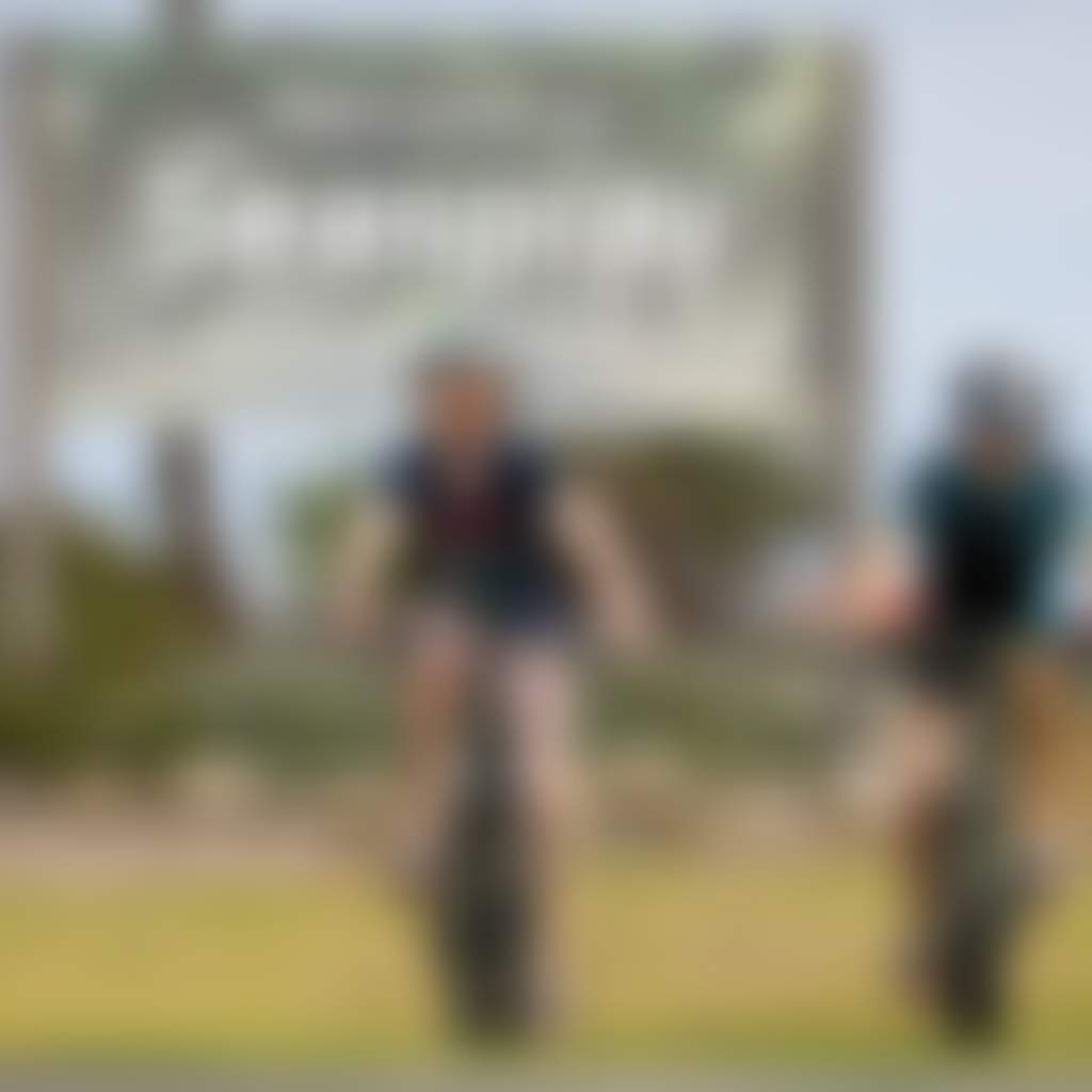 Children riding bikes in front of Seaspray entrance sign