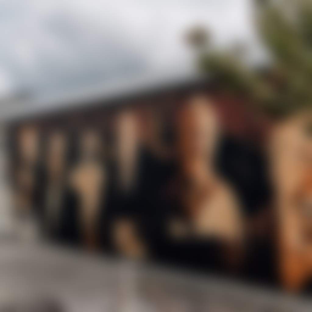 Heesco Town couple walking past mural of mens faces