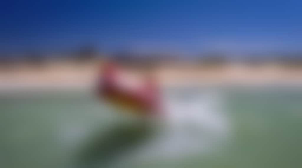 Seaspray Surf Lifesaving Club boat in surf on beach