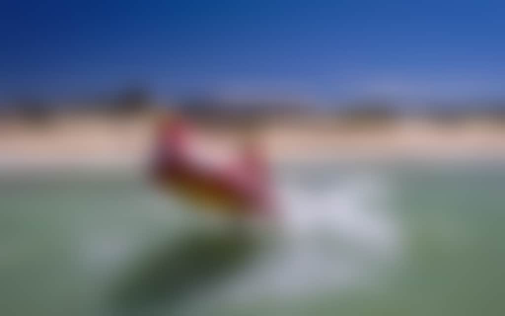 Seaspray Surf Lifesaving Club boat in surf on beach