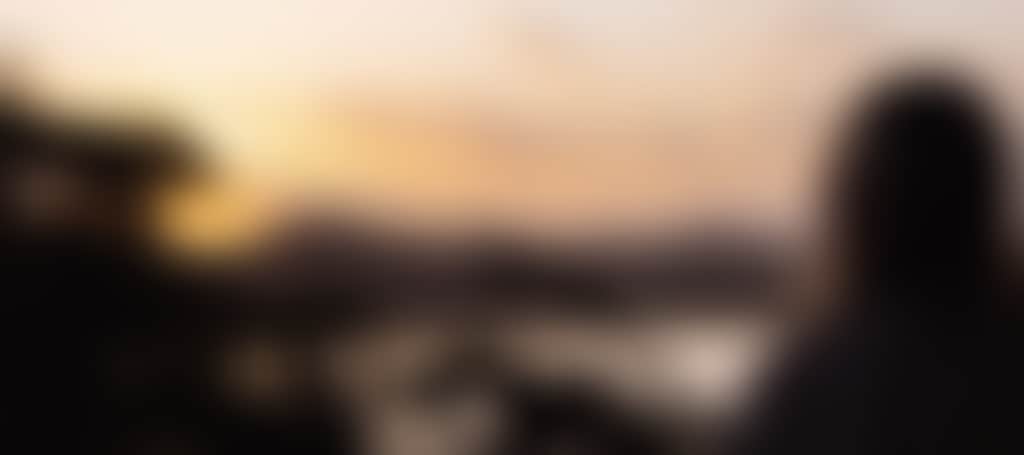 Marlo girl on balcony overlooking lake at sunset