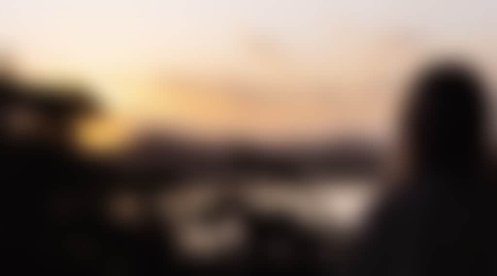 Marlo girl on balcony overlooking lake at sunset