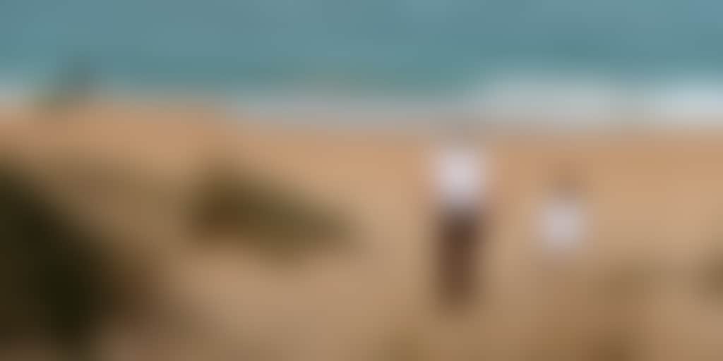 Loch Sport beach parent and child walking toward sea with fisherman