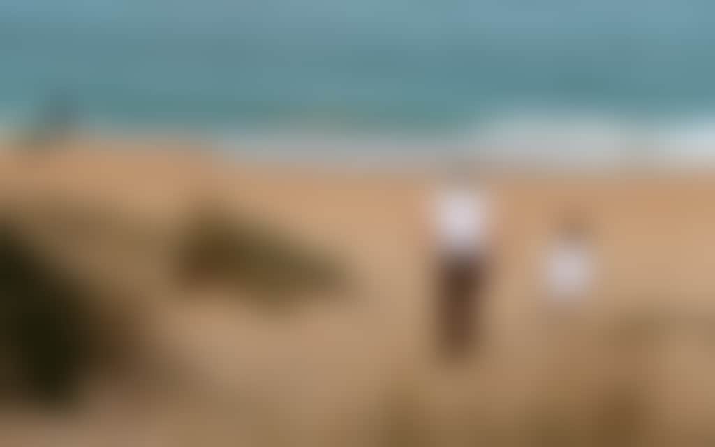 Loch Sport beach parent and child walking toward sea with fisherman