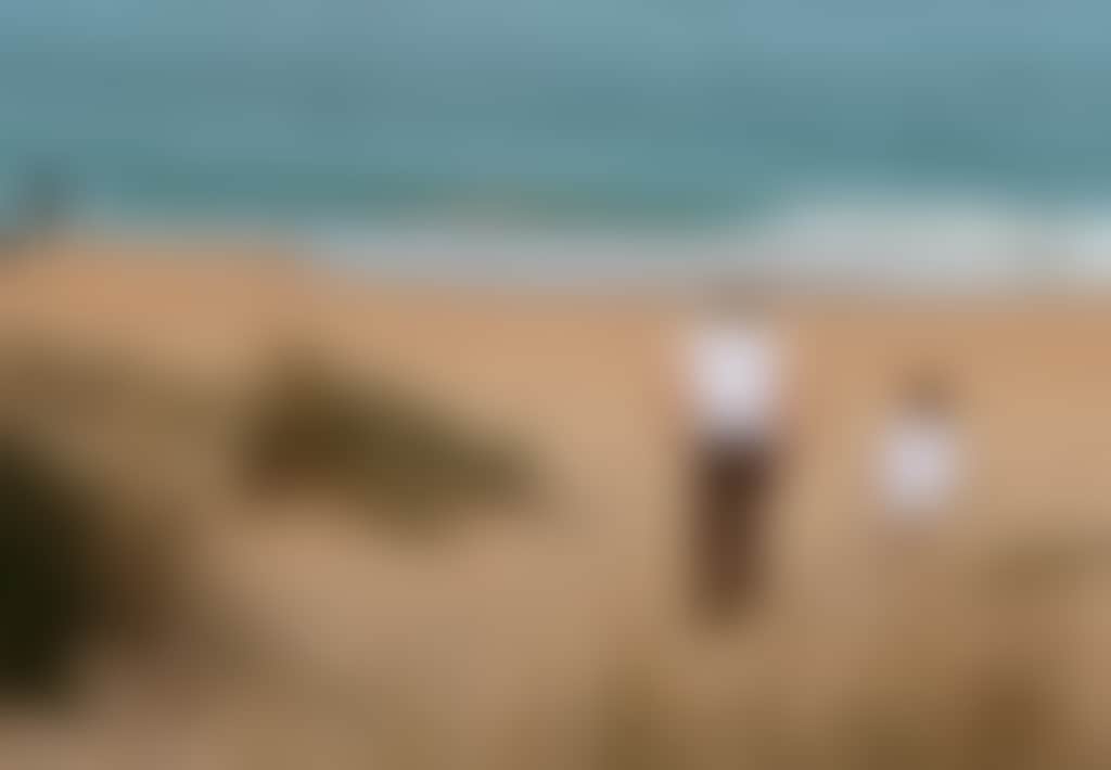Loch Sport beach parent and child walking toward sea with fisherman
