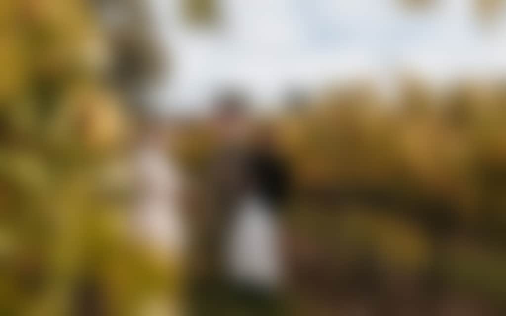 Narkoojee ladies standing amongst golden autumn vines in Traralgon winery