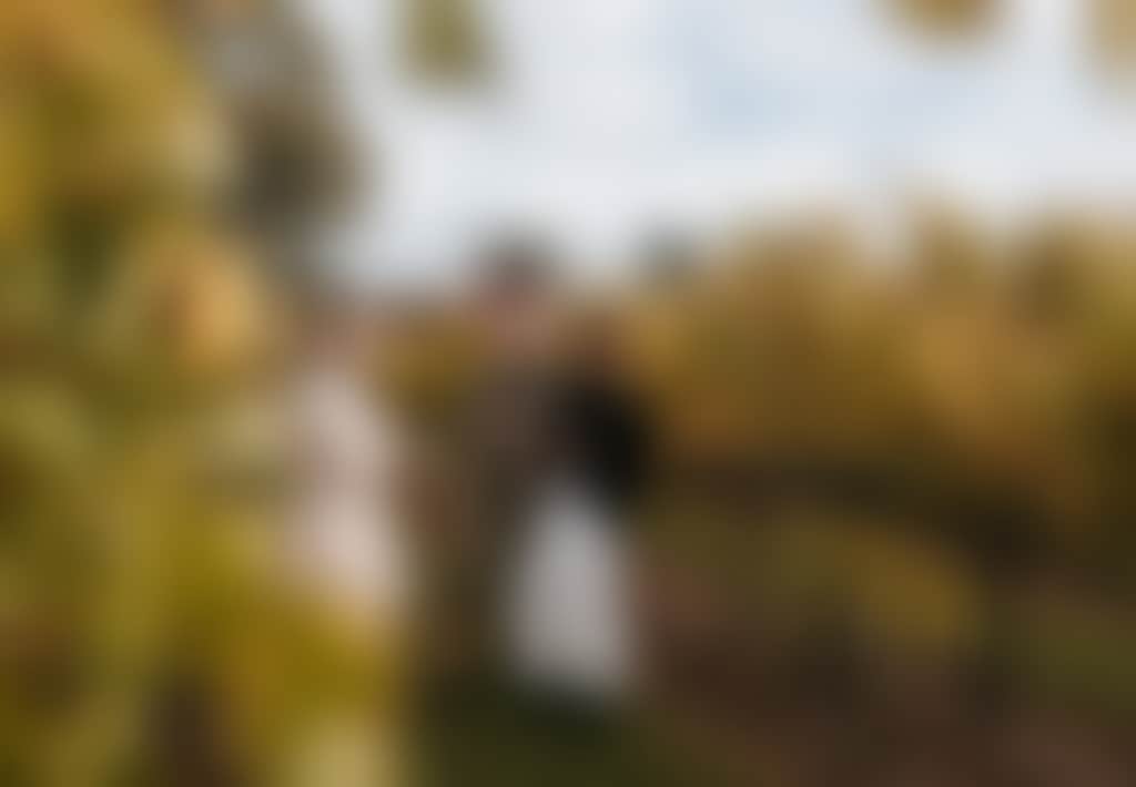 Narkoojee ladies standing amongst golden autumn vines in Traralgon winery