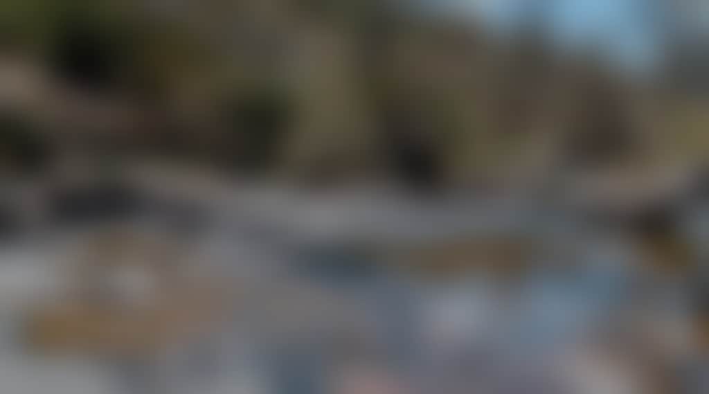 Woman sitting on rocks beside river at Little River Falls