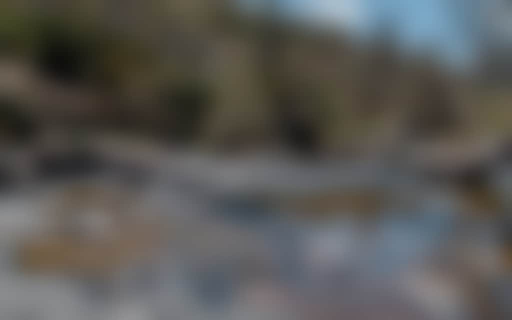 Woman sitting on rocks beside river at Little River Falls