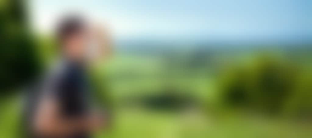 Guy with camera overlooking green hills on the Great Southern Rail Trail