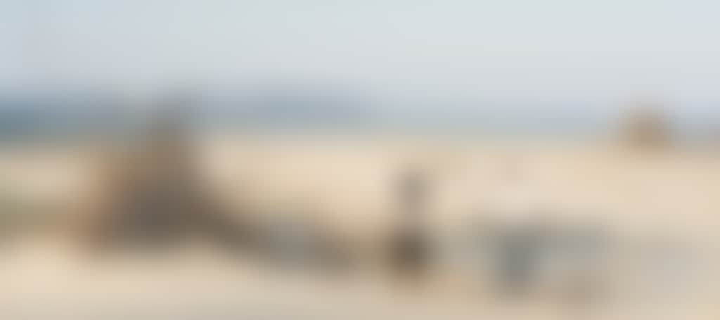 Inverloch Beach couple walking around driftwood sculpture
