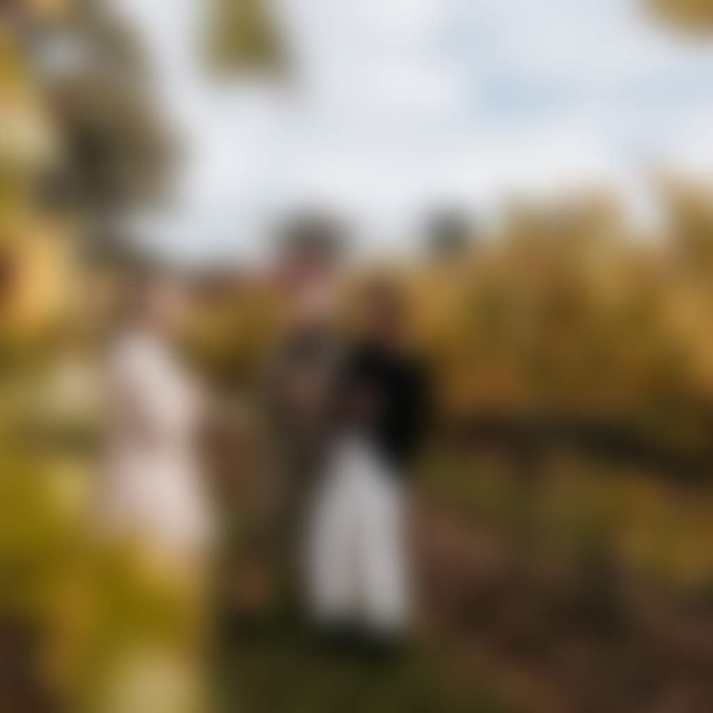 Narkoojee ladies standing amongst golden autumn vines in Traralgon winery