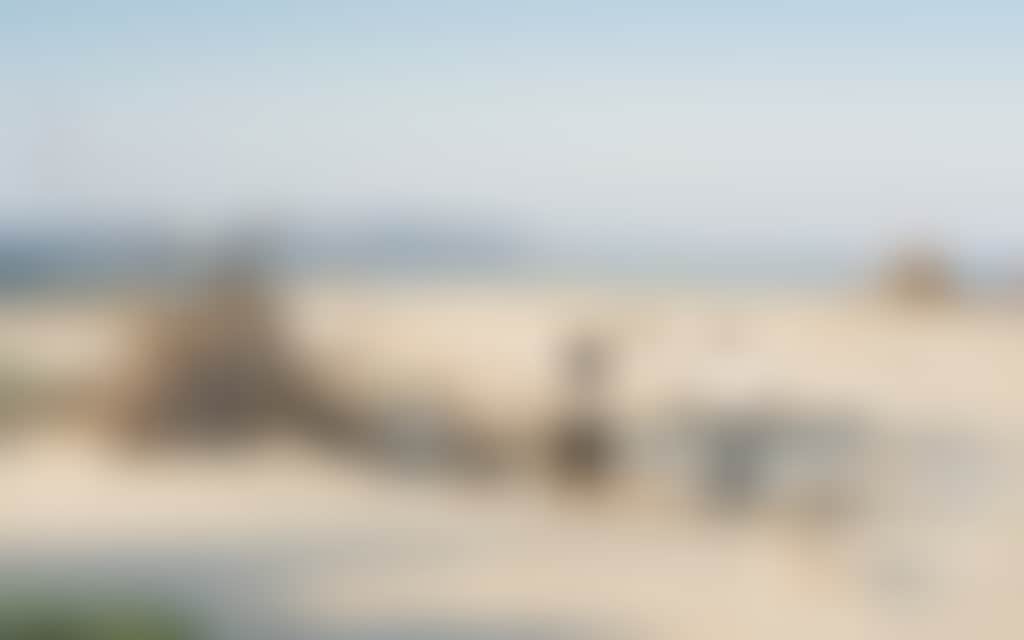 Couple admiring driftwood teepee hut on Inverloch beach