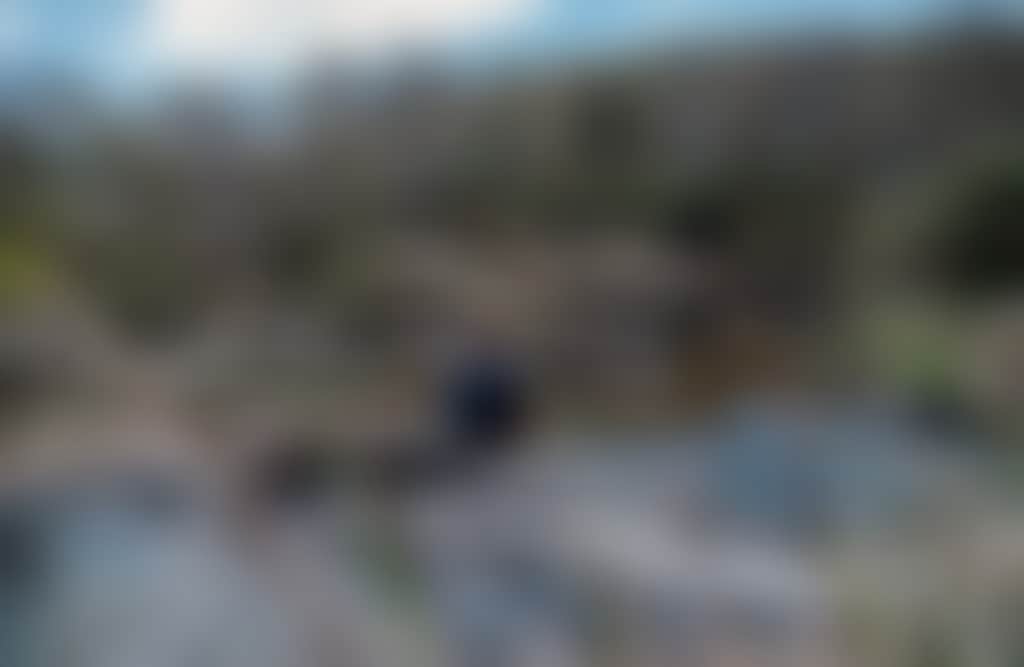 Little River Falls Snowy River National Park girl sitting at rock pools at top of waterfall
