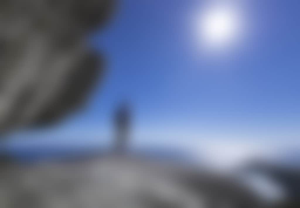 Man standing on rock overlooking water at Wilsons Promontory