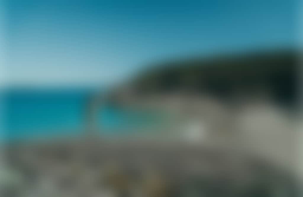 Squeaky Beach girl standing on boulder at Wilsons Promontory turquoise water 1