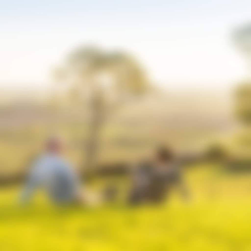 Couple drinking wine on the grass at sunset at Lightfoot Wines