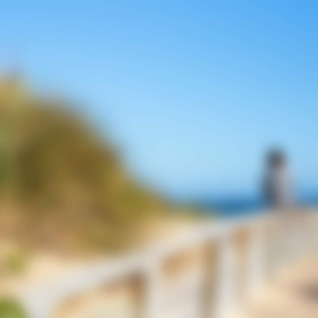 Woman sitting on the beach with grasses at Main Beach Lakes Entrance